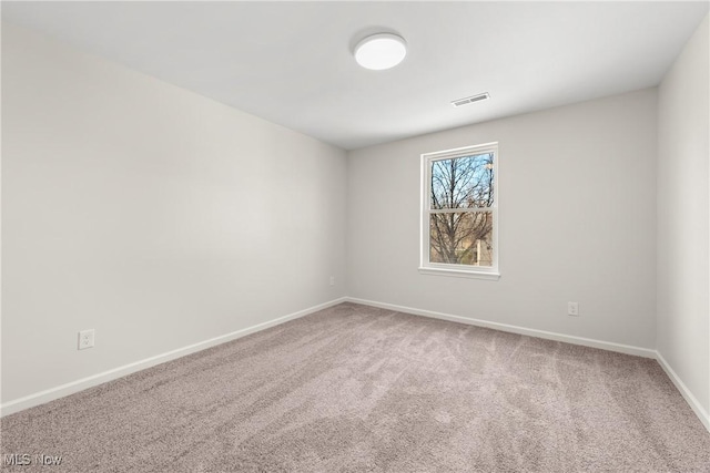 unfurnished room featuring visible vents, carpet, and baseboards