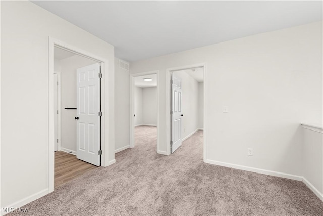 spare room with visible vents, carpet flooring, and baseboards