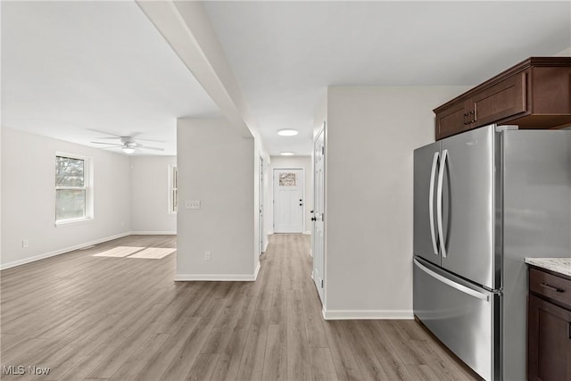 kitchen with a ceiling fan, baseboards, freestanding refrigerator, dark brown cabinetry, and light wood-type flooring