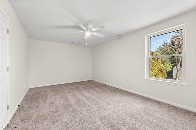 carpeted empty room featuring visible vents, baseboards, and a ceiling fan