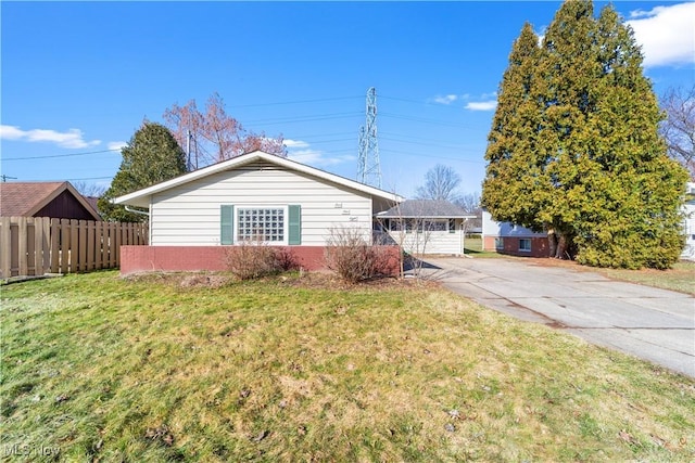 single story home with concrete driveway, a front yard, and fence