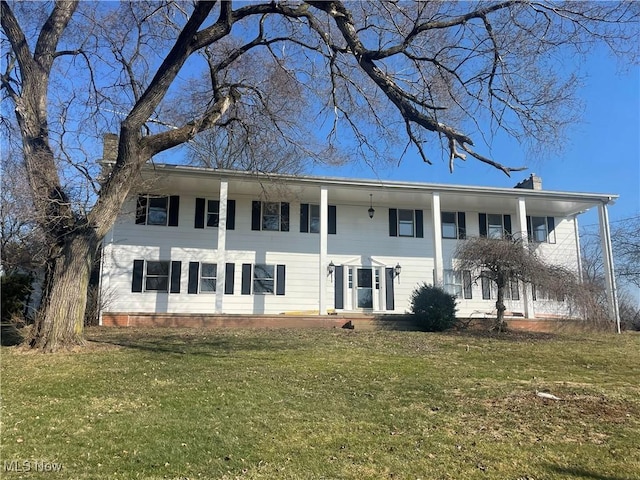 view of front of house with a front yard and a chimney