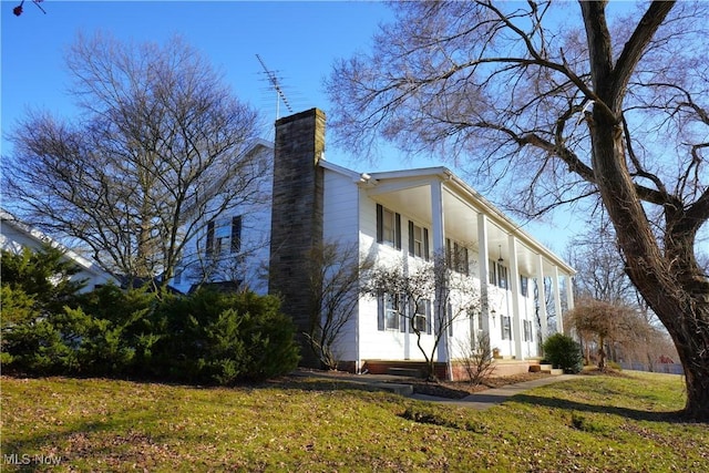 3390 Meese Rd NE, Louisville, OH 44641 - view of side of home featuring a lawn and a chimney