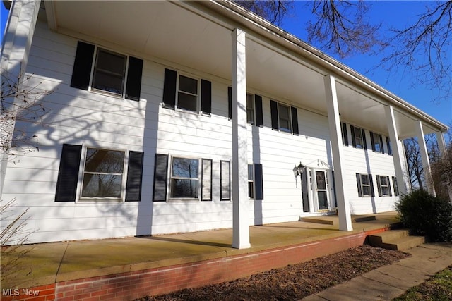 view of side of home featuring covered porch