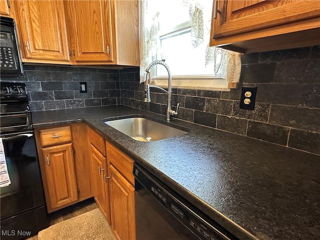 kitchen featuring a sink, black microwave, dishwasher, range, and tasteful backsplash