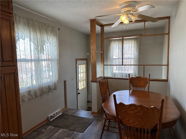 dining area with visible vents, a textured ceiling, wood finished floors, and a ceiling fan