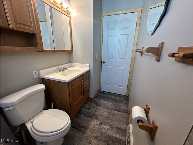 bathroom with toilet, wood finished floors, and vanity