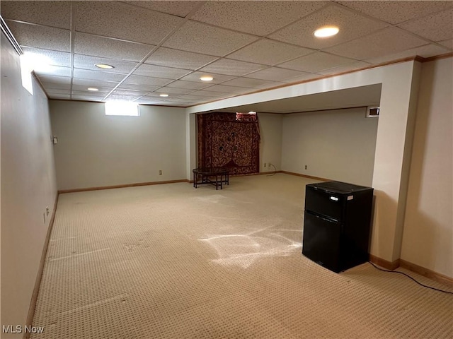 basement with baseboards, carpet floors, and freestanding refrigerator