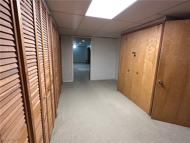 hallway featuring a drop ceiling and carpet floors