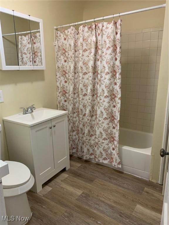 full bath featuring vanity, toilet, wood finished floors, and shower / bath combo