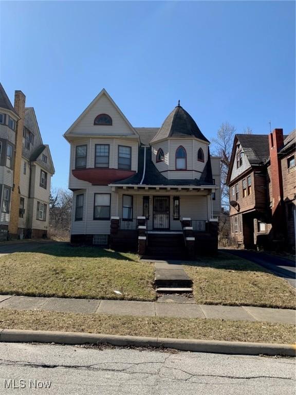 victorian-style house with a front lawn and covered porch