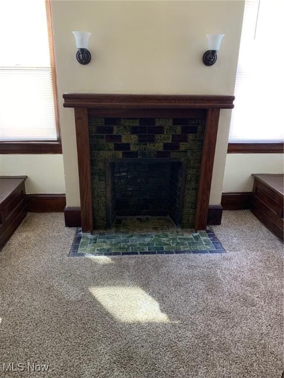 interior details with baseboards, carpet, and a tile fireplace