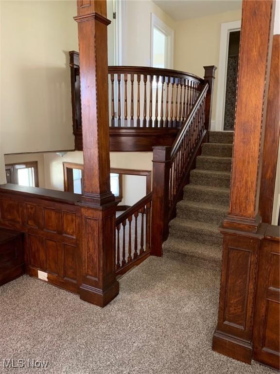 stairs with carpet and ornate columns