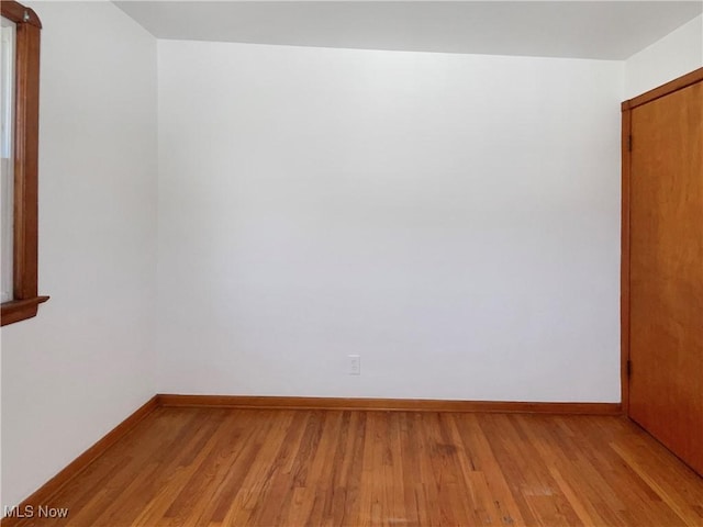 empty room with baseboards and light wood-style flooring