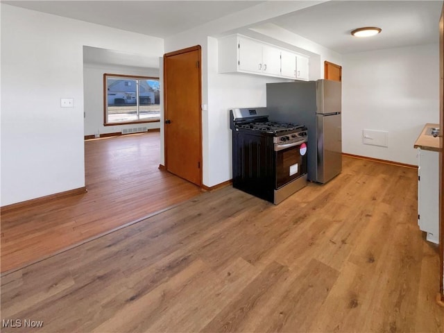 kitchen featuring visible vents, baseboards, light wood-style flooring, stainless steel appliances, and white cabinetry