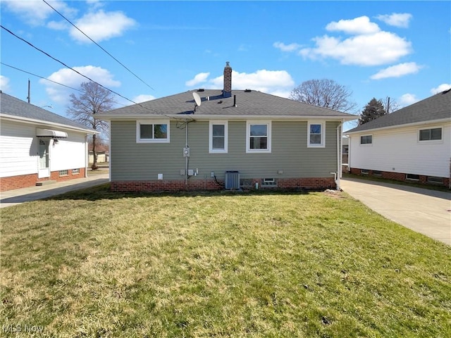 back of property with cooling unit, a lawn, and a chimney