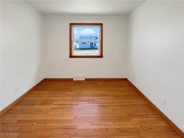 unfurnished room featuring visible vents, light wood-style flooring, and baseboards