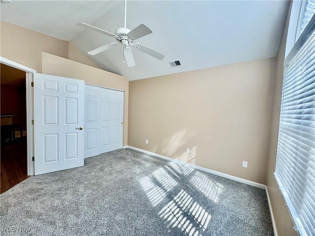 unfurnished bedroom with visible vents, lofted ceiling, baseboards, and a closet