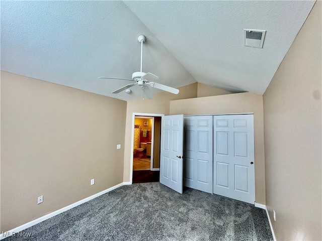 unfurnished bedroom featuring a textured ceiling, baseboards, lofted ceiling, and carpet