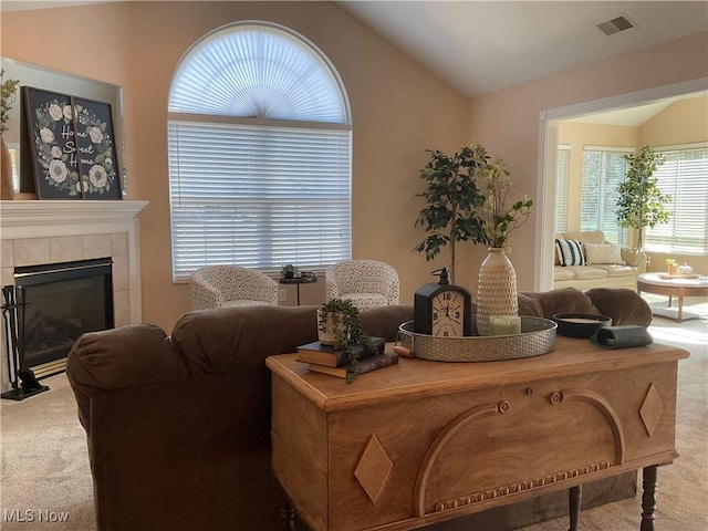 carpeted living room featuring visible vents, a fireplace, and lofted ceiling