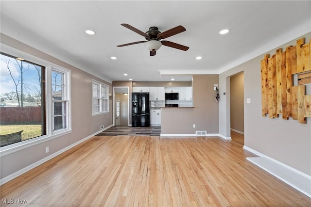 unfurnished living room with visible vents, baseboards, light wood-style flooring, and a ceiling fan