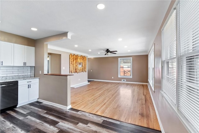 kitchen featuring dishwashing machine, baseboards, decorative backsplash, dark wood-type flooring, and white cabinetry