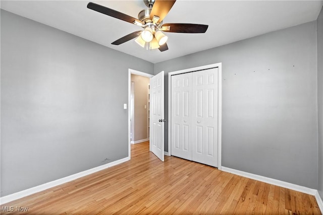 unfurnished bedroom with a closet, baseboards, a ceiling fan, and light wood finished floors