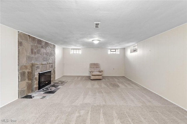 below grade area with a fireplace, carpet, and visible vents