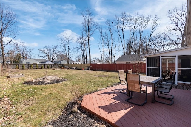 deck with a fenced backyard, outdoor dining area, a yard, and a sunroom