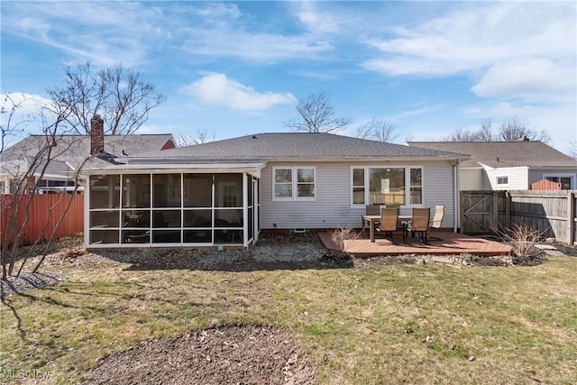 back of house with a yard, a wooden deck, a fenced backyard, and a sunroom