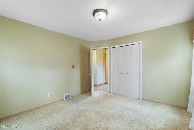 unfurnished bedroom with carpet flooring, baseboards, and visible vents