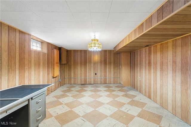 unfurnished room featuring light floors and wood walls