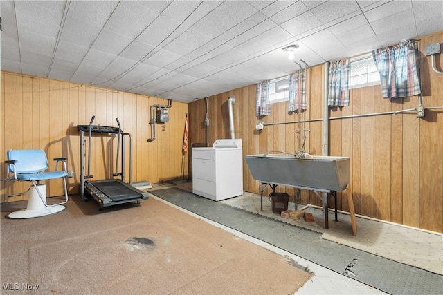 workout area with washer / dryer, wood walls, and a sink