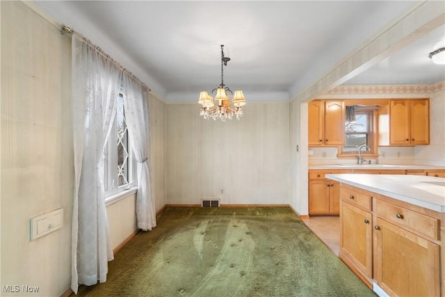 kitchen featuring visible vents, a sink, an inviting chandelier, light countertops, and light colored carpet