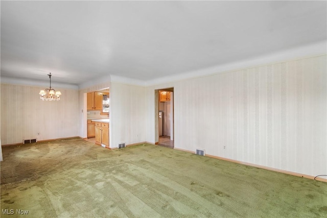 unfurnished living room featuring visible vents, light colored carpet, and a chandelier