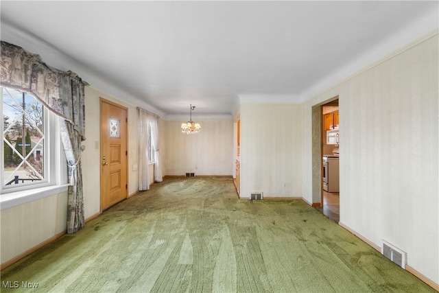 unfurnished living room featuring visible vents, carpet flooring, baseboards, and an inviting chandelier