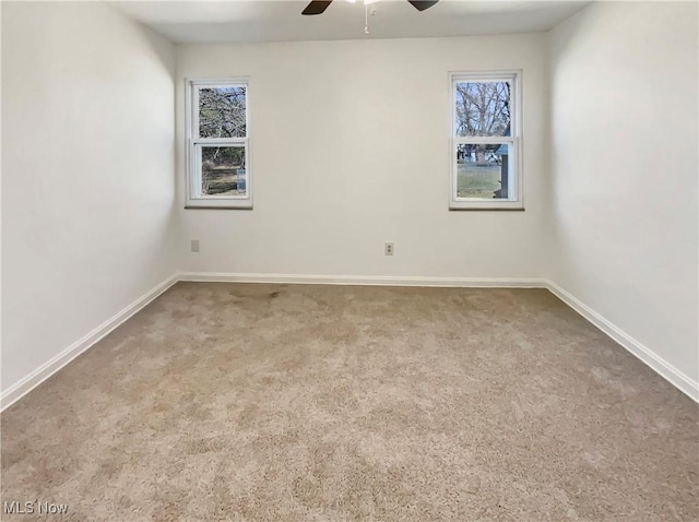 spare room with baseboards, a ceiling fan, and carpet floors