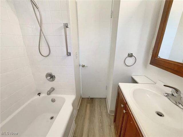 bathroom with vanity, wood finished floors, and bathtub / shower combination