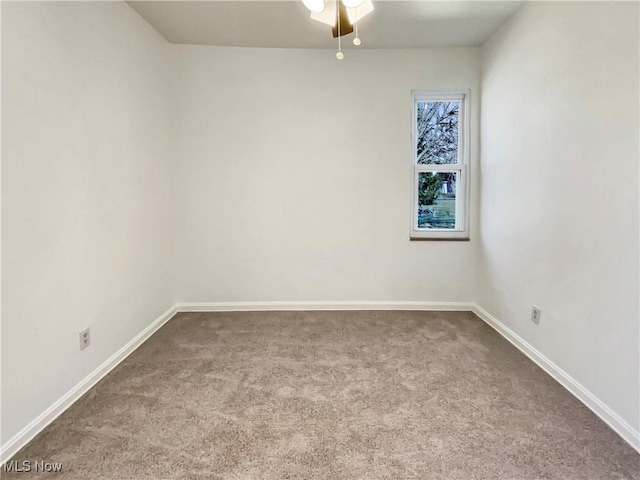 carpeted empty room featuring baseboards and a ceiling fan