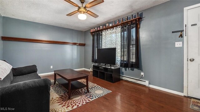 living area with baseboards, wood finished floors, a textured ceiling, a ceiling fan, and a baseboard radiator