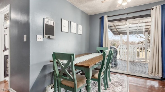 dining room with a textured ceiling, wood finished floors, and a ceiling fan