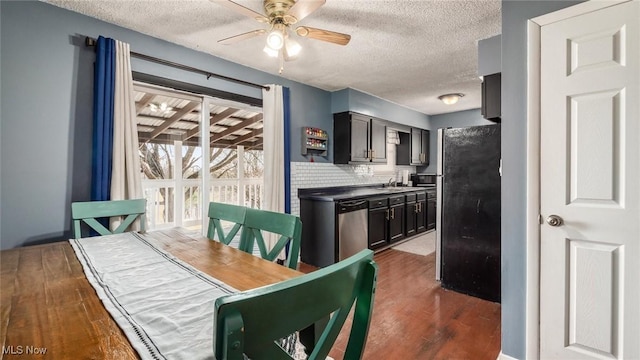 dining area with a textured ceiling, wet bar, dark wood-type flooring, and ceiling fan