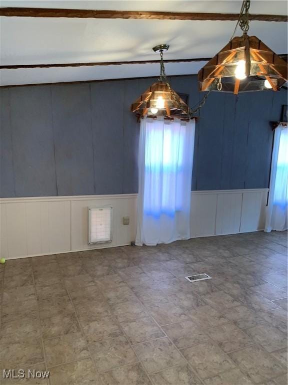 unfurnished dining area featuring visible vents and a decorative wall