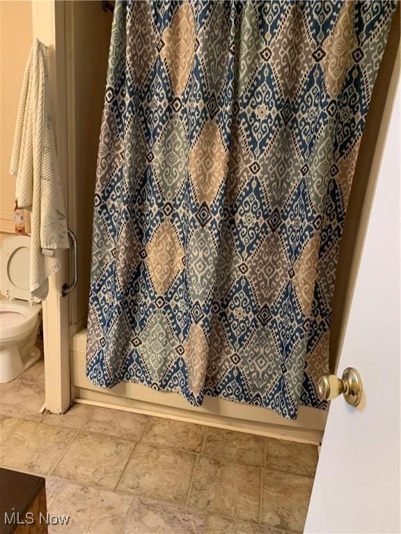 bathroom with tile patterned floors, toilet, and shower / bath combo