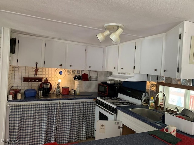 kitchen featuring white gas range, tasteful backsplash, black microwave, and a sink