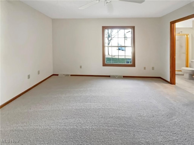 unfurnished room with visible vents, a ceiling fan, and carpet floors