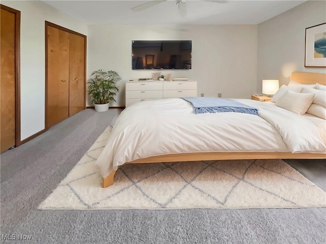 bedroom featuring carpet flooring, two closets, and baseboards