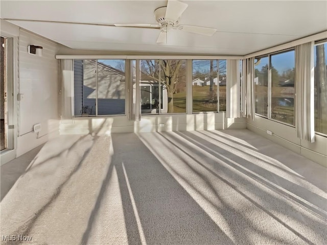 unfurnished sunroom featuring ceiling fan