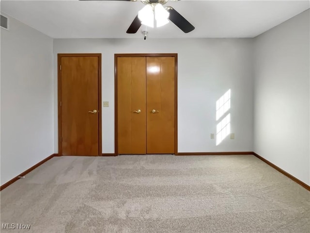 unfurnished bedroom with visible vents, baseboards, light colored carpet, and ceiling fan