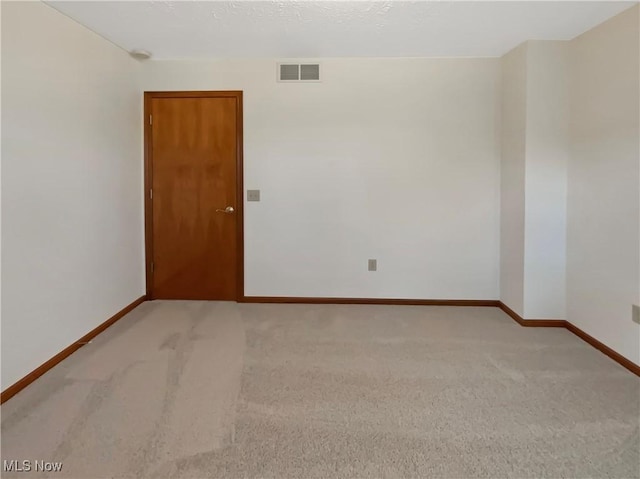 unfurnished room featuring baseboards, visible vents, and carpet floors